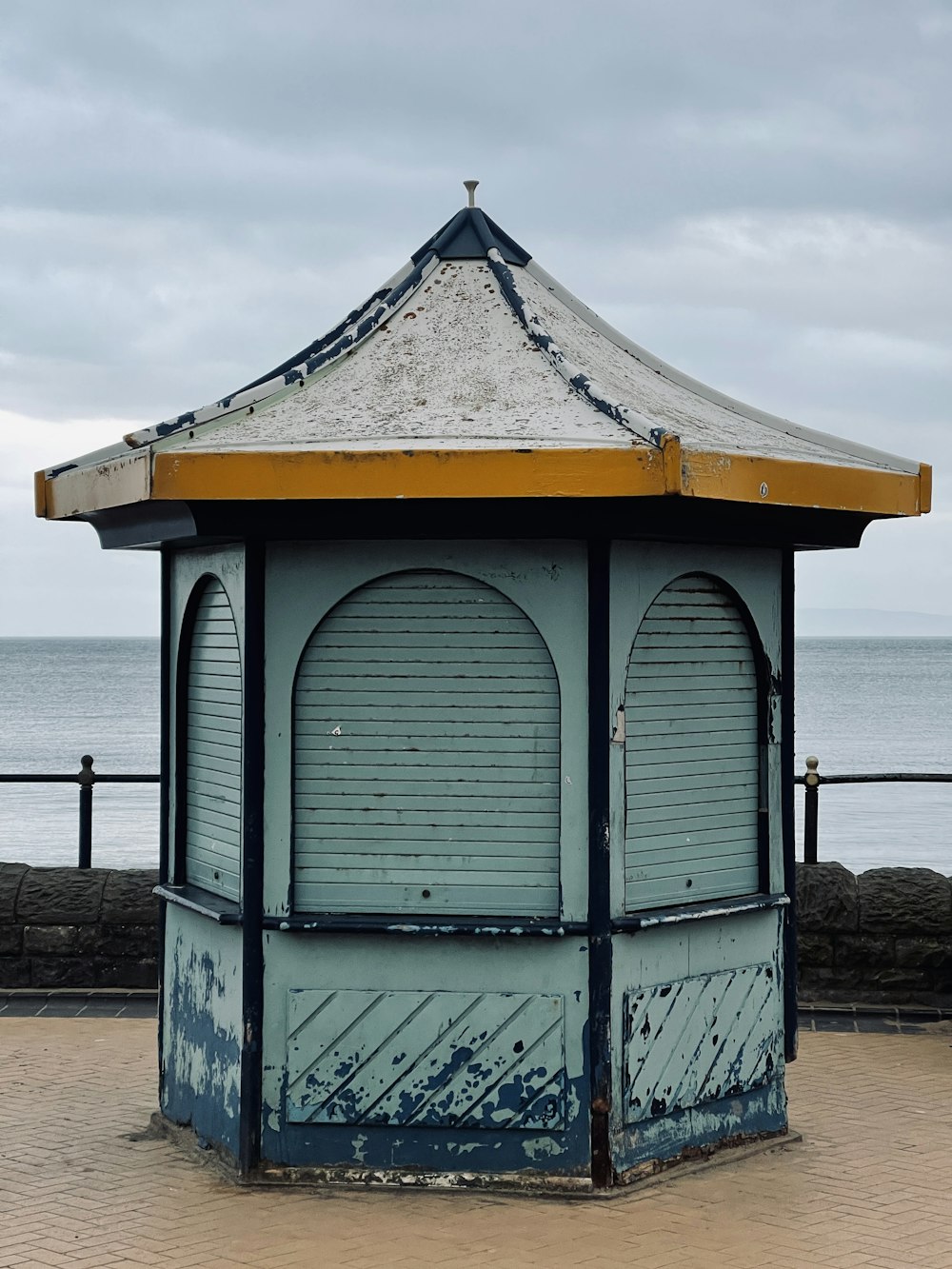 a blue and white shelter sitting on top of a brick walkway