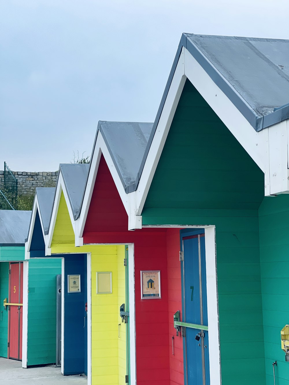 a row of brightly colored beach huts next to each other