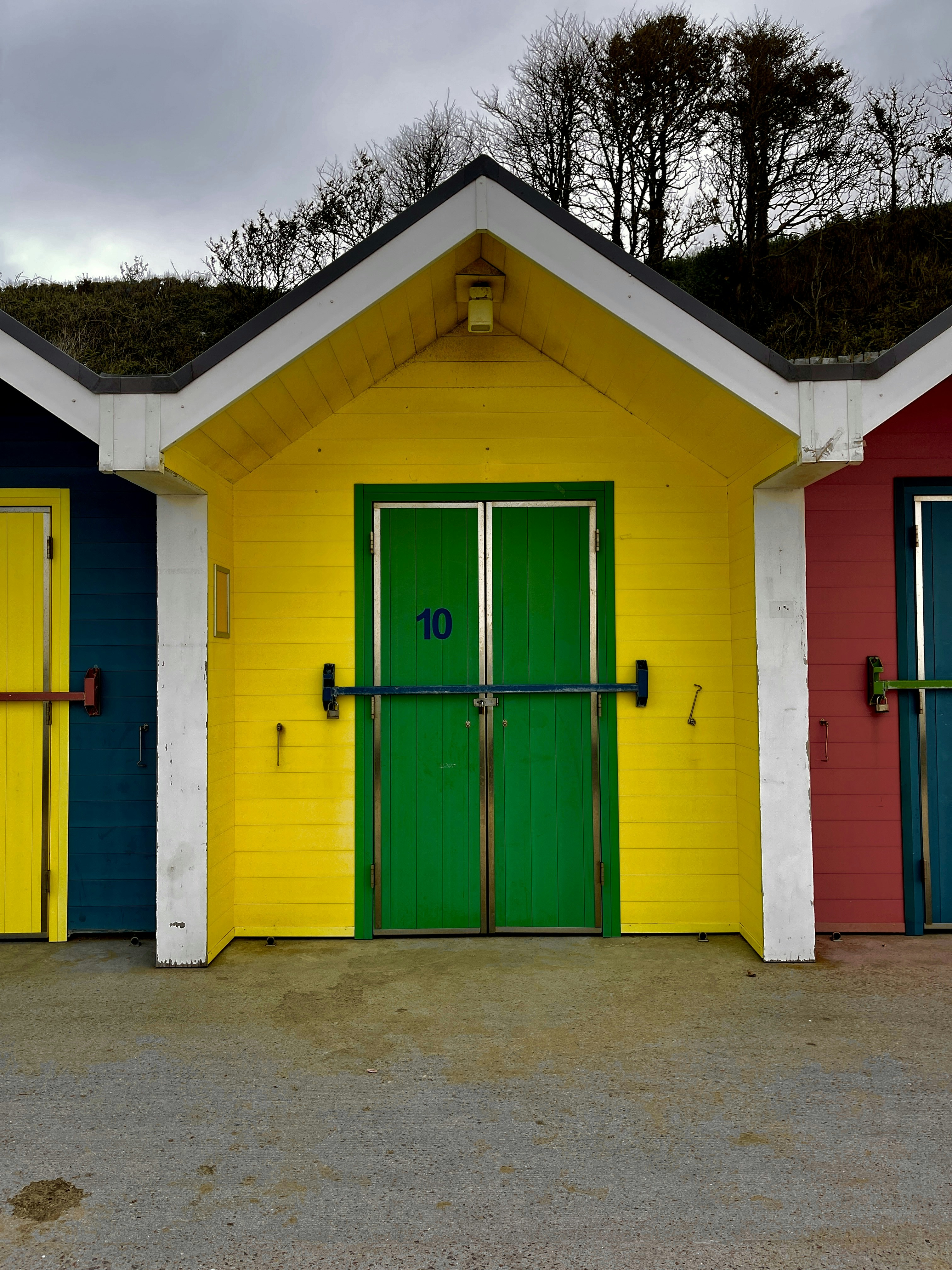 a row of brightly colored garage doors in front of a building