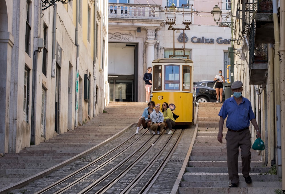 people riding on yellow and white tram during daytime