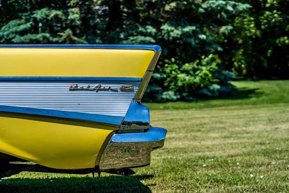 yellow and blue car on green grass field during daytime