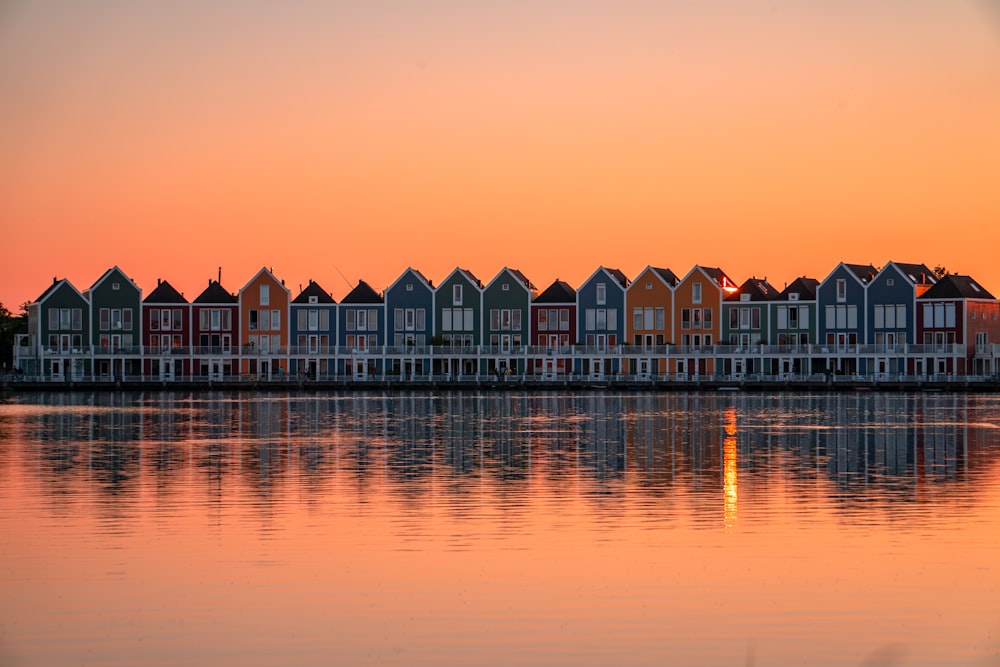 white and brown house on water during sunset