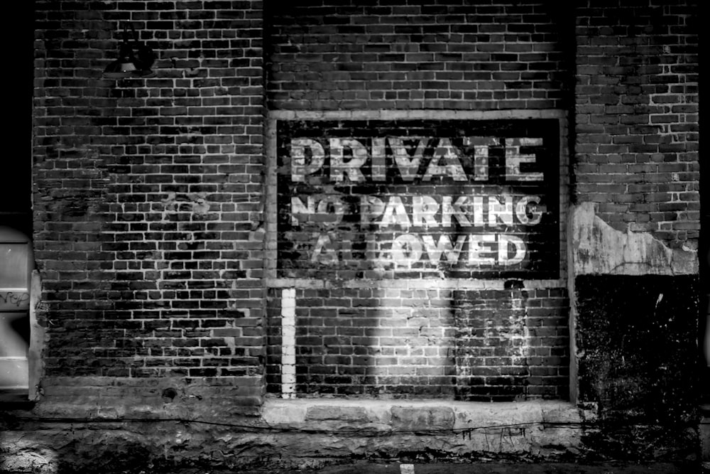 a black and white photo of a private parking sign