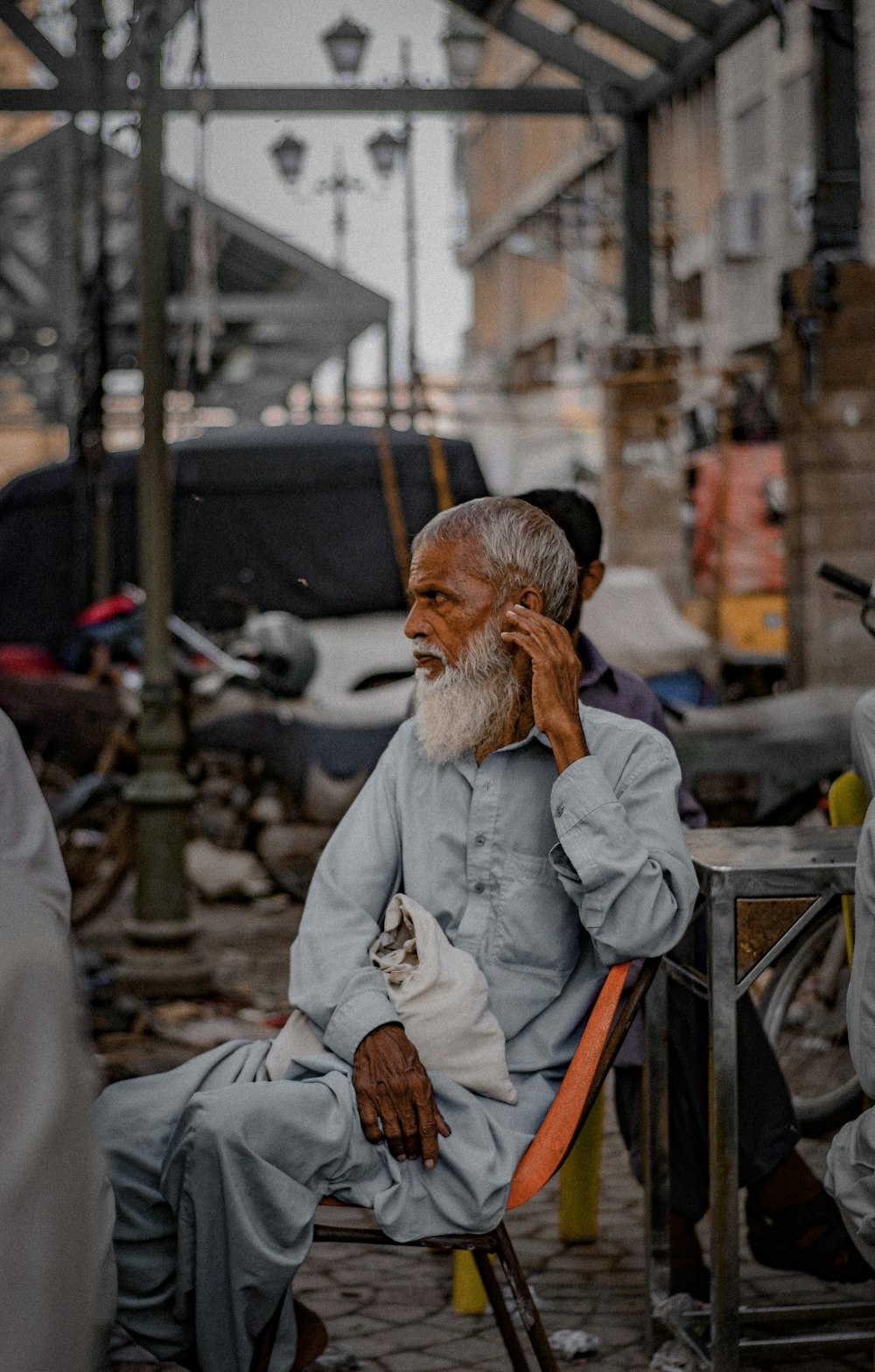 a man sitting in a chair talking on a cell phone