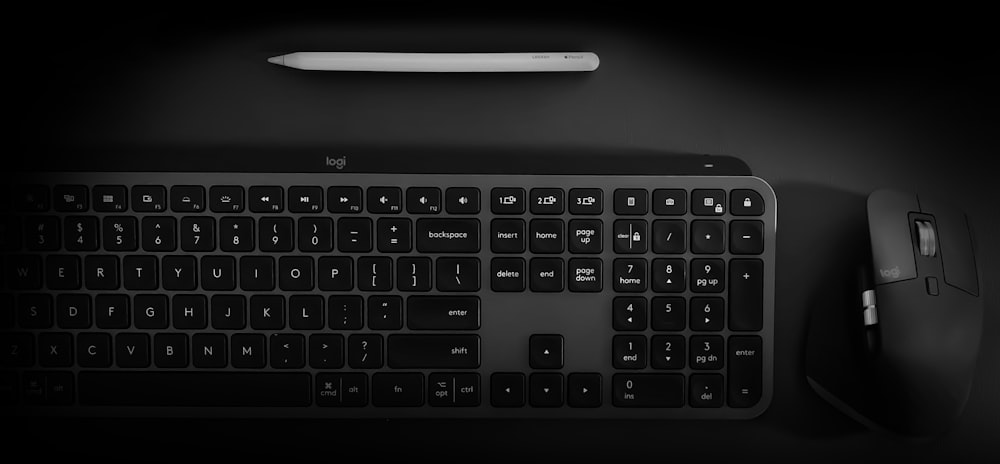 a computer keyboard and mouse on a black surface