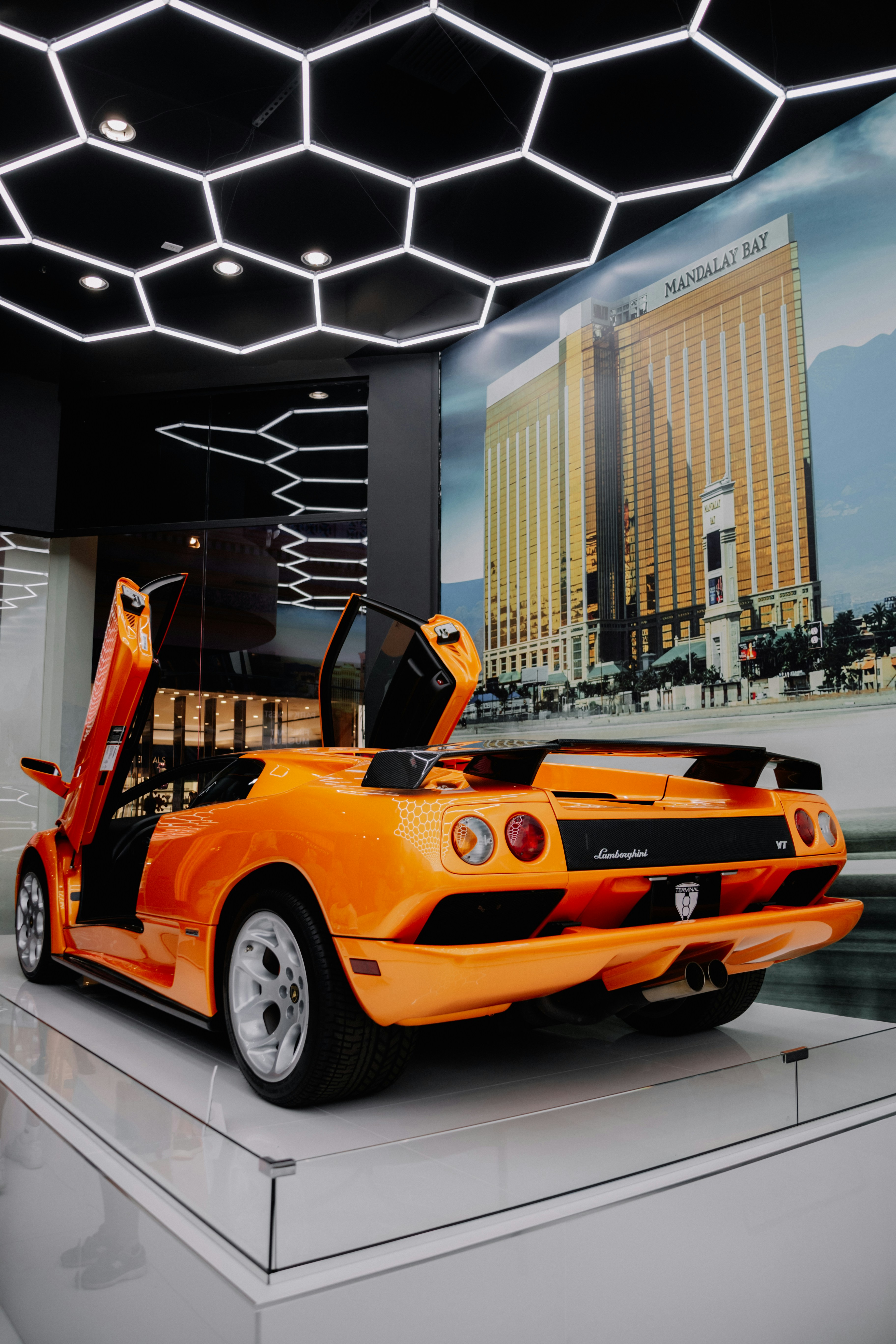 An orange sports car on display in a showroom photo – Free Sports car ...