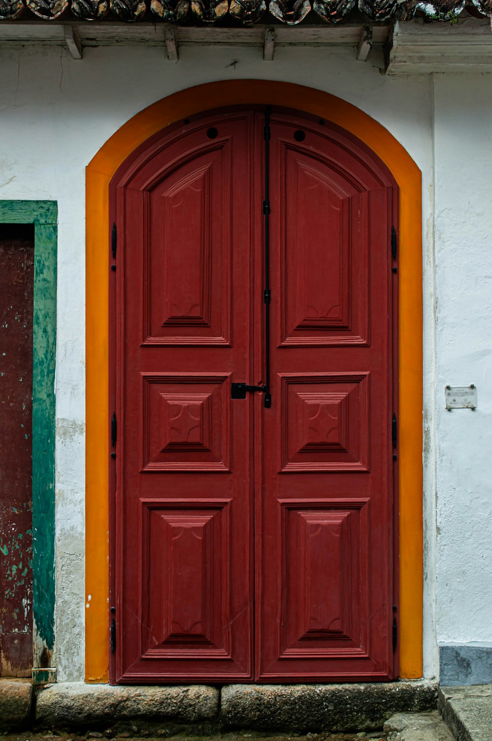 a red door is open in front of a white building