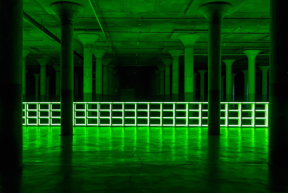 a large room with columns and green lights
