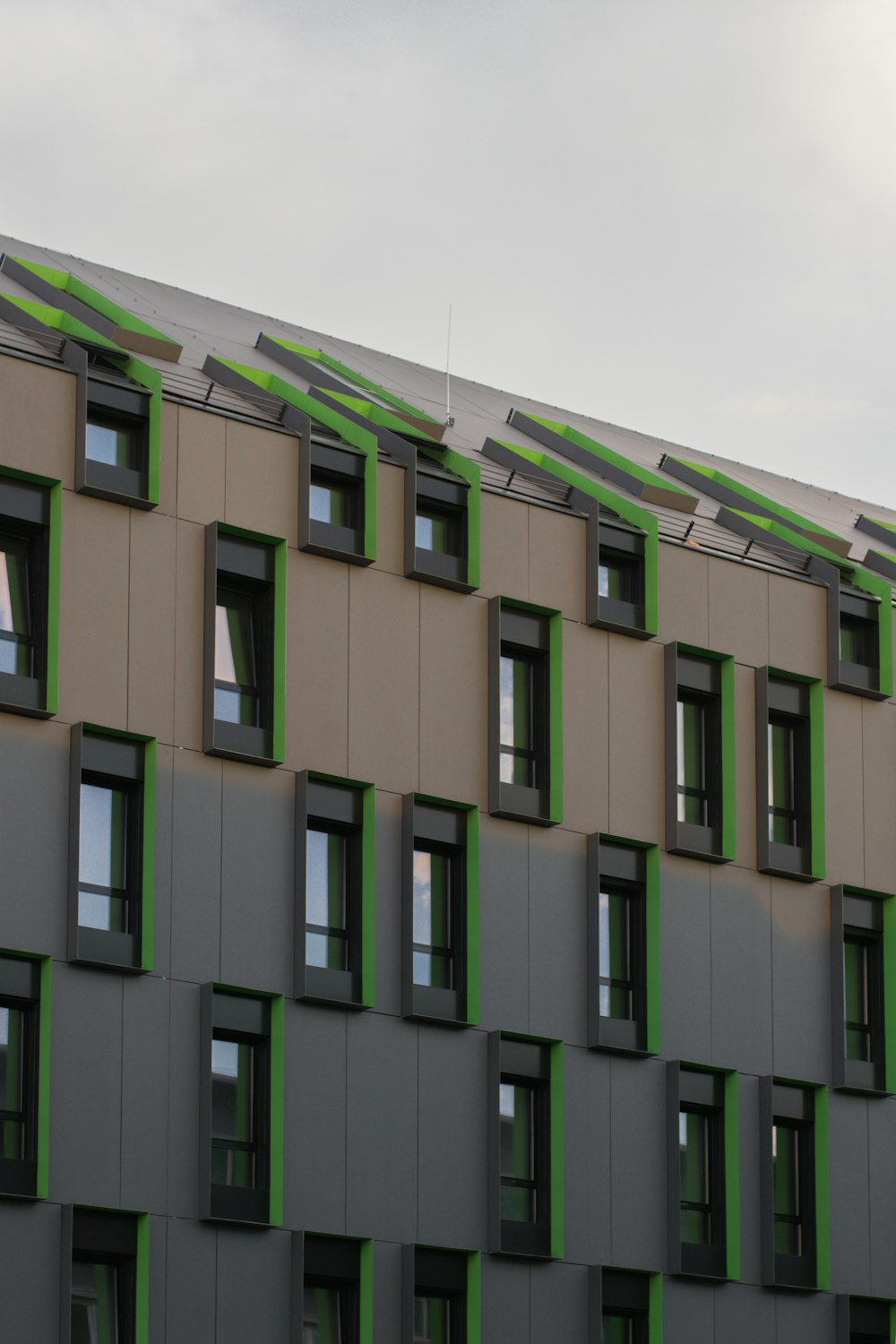 ein hohes Gebäude mit vielen Fenstern und grünen Verkleidungen