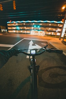 a person riding a bike down a street at night