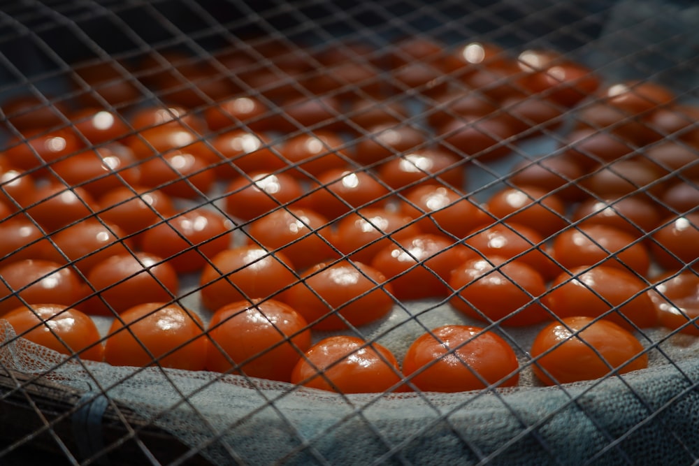 a bunch of tomatoes that are in a mesh bag