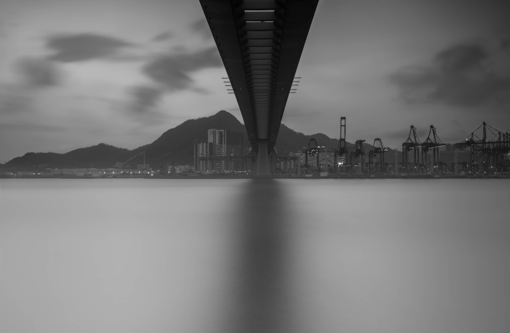a black and white photo of a bridge over water