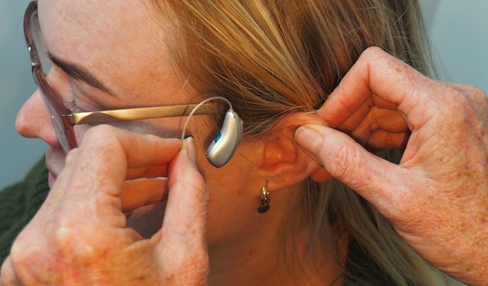 a woman is putting on a pair of glasses