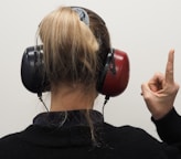 a woman wearing headphones pointing to the side