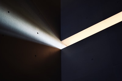 a light shines brightly on a dark wall