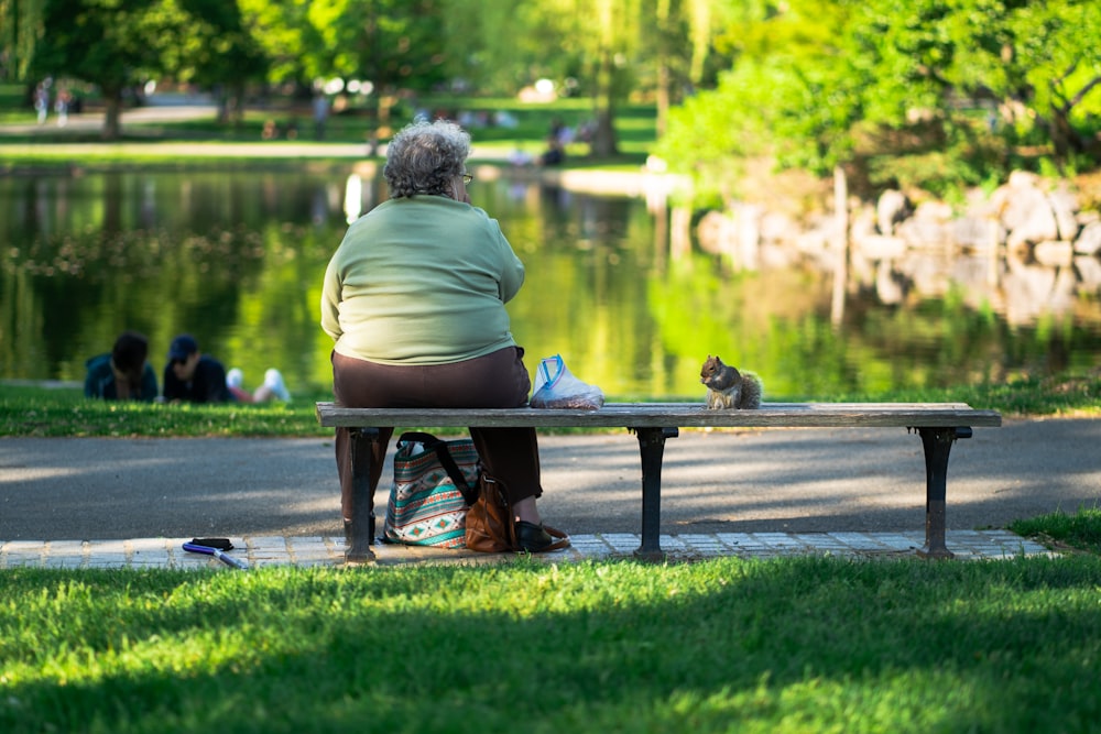 a woman sitting on a bench next to a cat