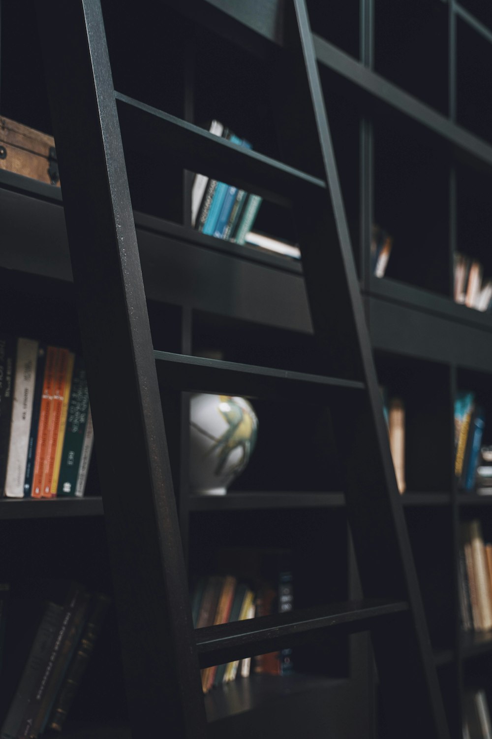 a bookshelf filled with lots of books and a ladder