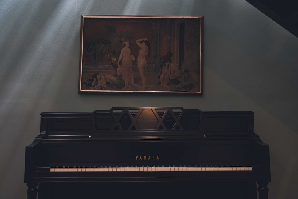 a piano in a room with a painting on the wall