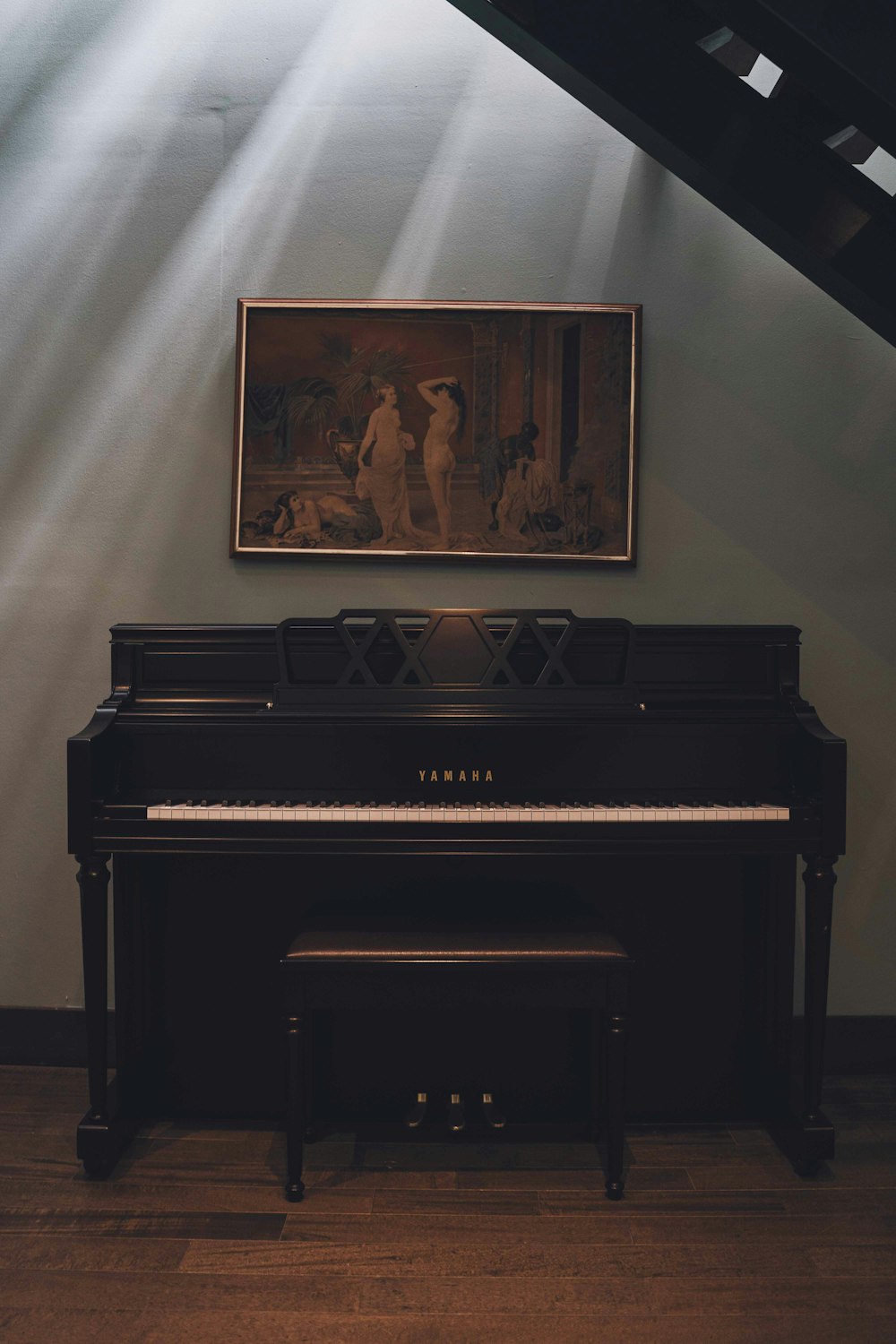 um piano em uma sala com uma pintura na parede