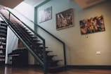 a stair case next to a book shelf and a piano