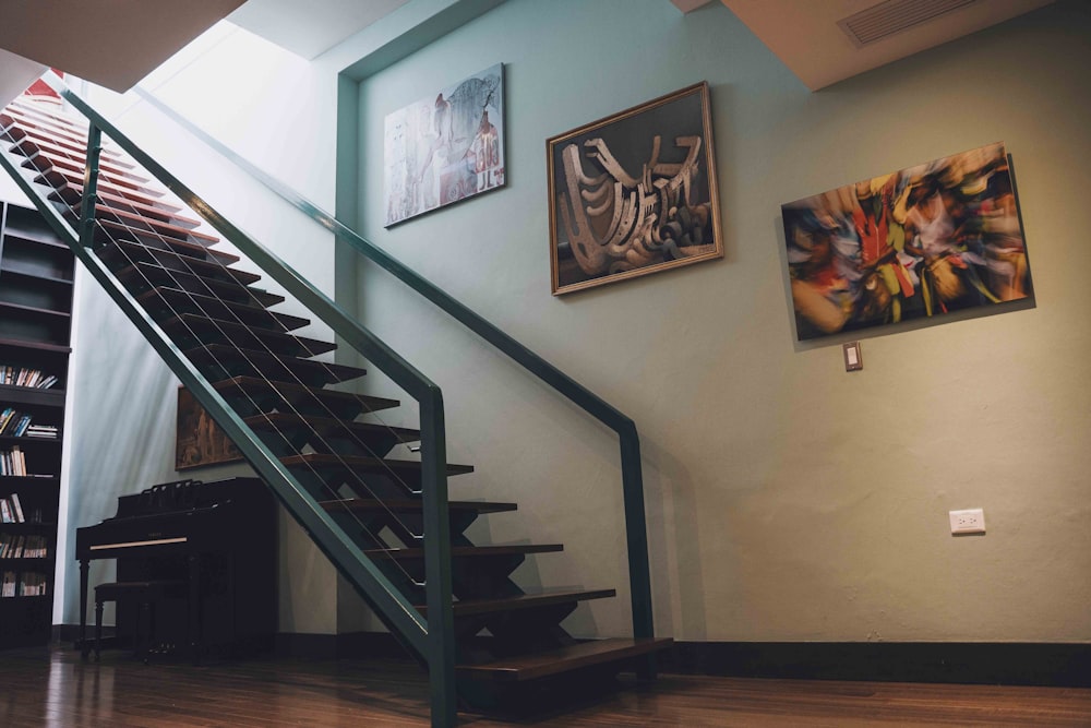 a stair case next to a book shelf and a piano