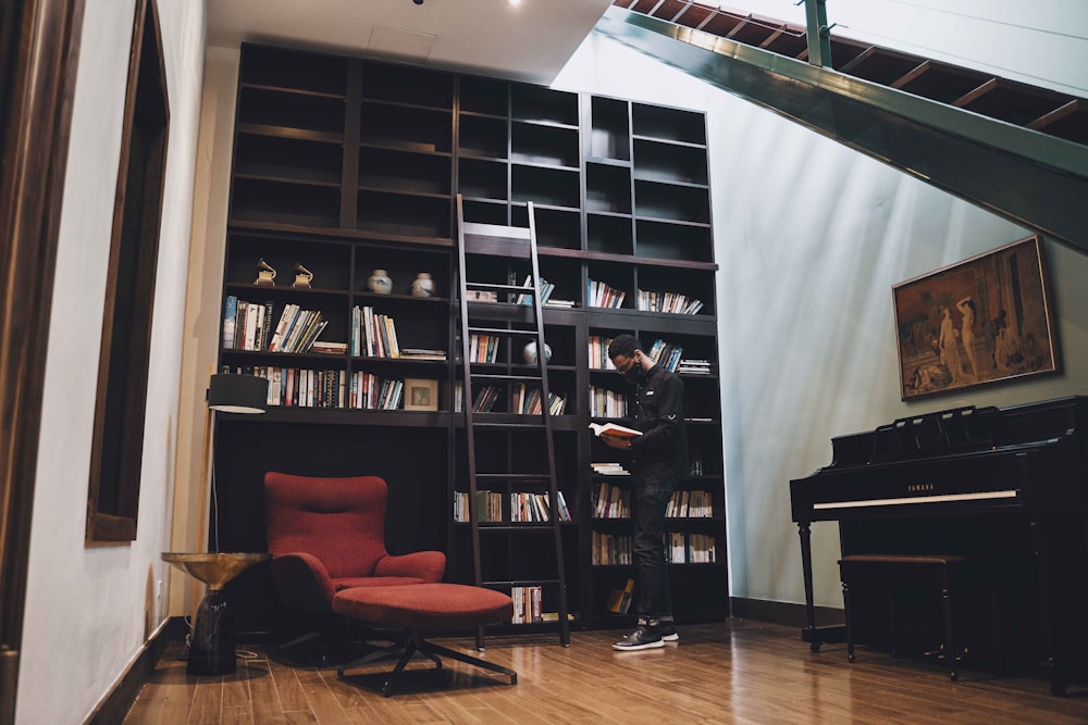 a red chair sitting in front of a book shelf filled with books