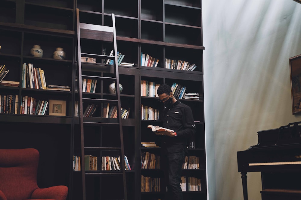 Un hombre parado frente a un estante de libros