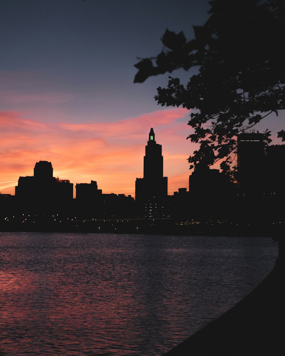 a sunset over a body of water with a city in the background