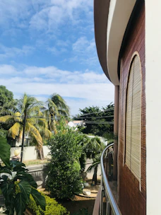 A cozy condo balcony overlooking a lush tropical garden.