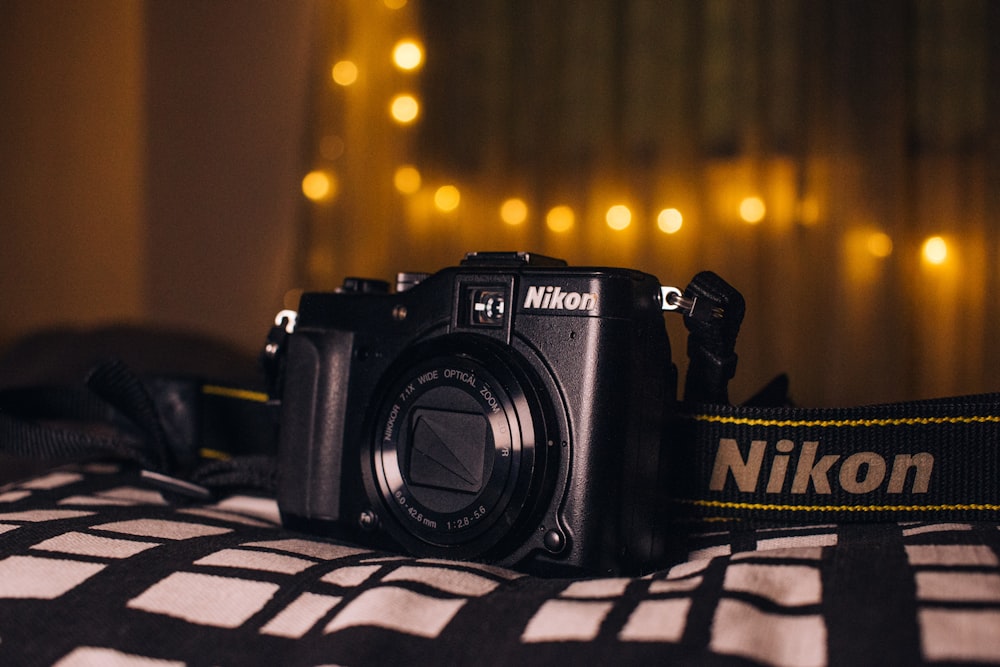 a nikon camera sitting on top of a bed