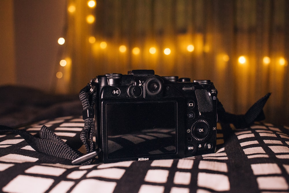 a camera sitting on top of a bed next to a window