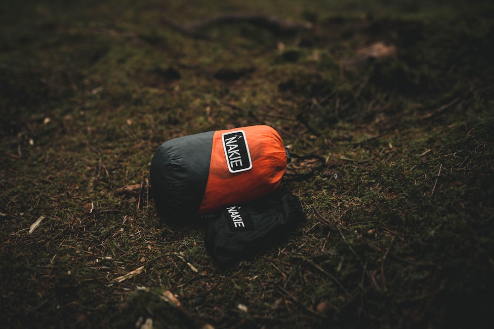 an orange and black jacket laying on the ground