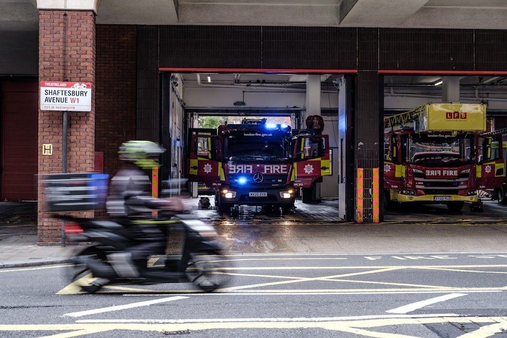 a man riding a motorcycle down a street next to a fire truck