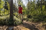 a man in red running through a forest
