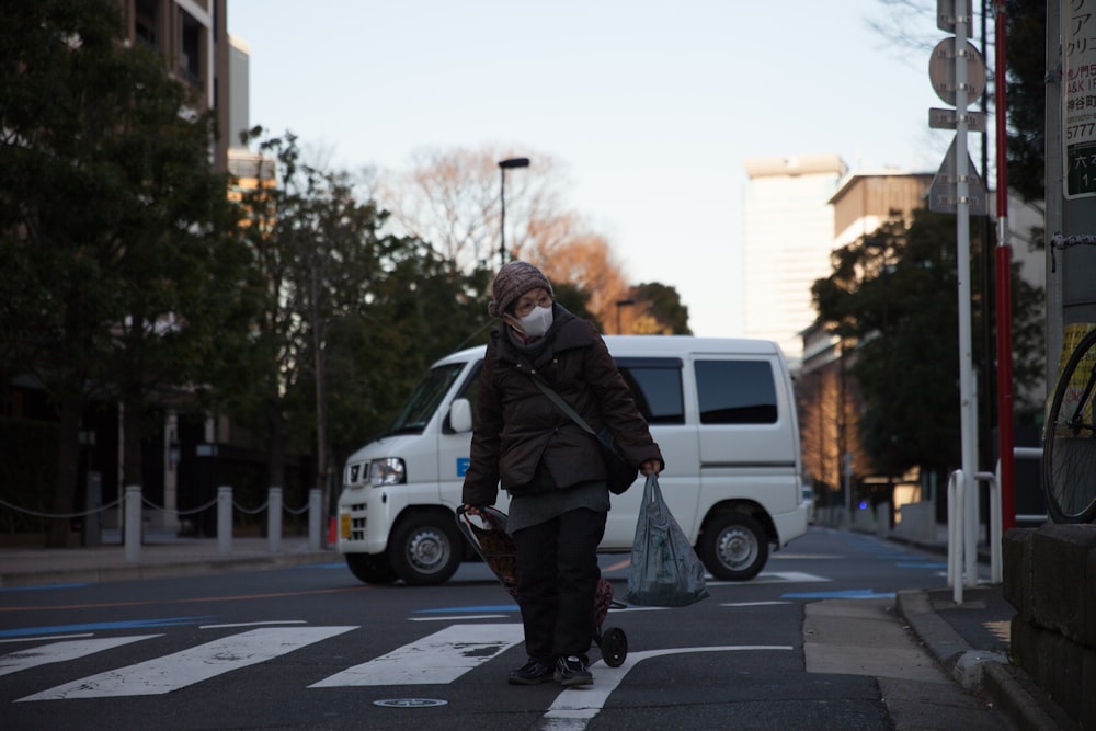 a person wearing a face mask crossing a street