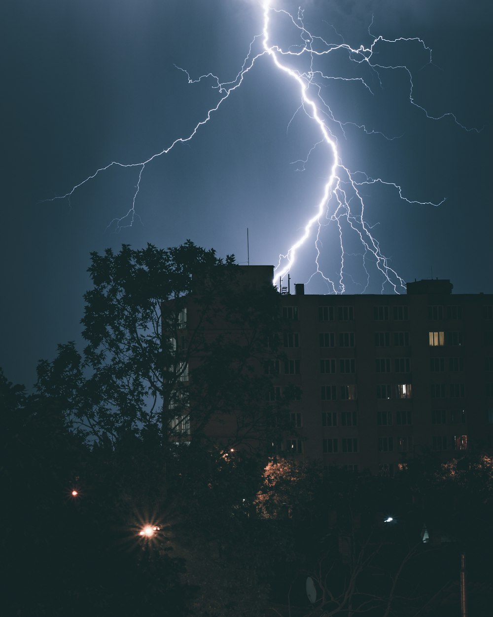 a lightning bolt strikes over a city at night