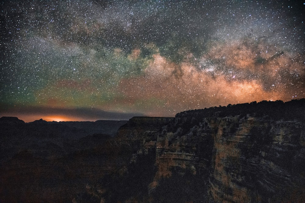 the night sky is filled with stars above a mountain