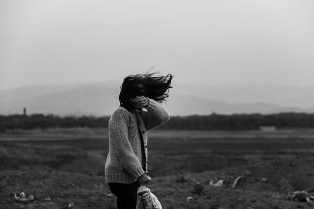 Una foto in bianco e nero di una donna con i capelli che soffiano al vento