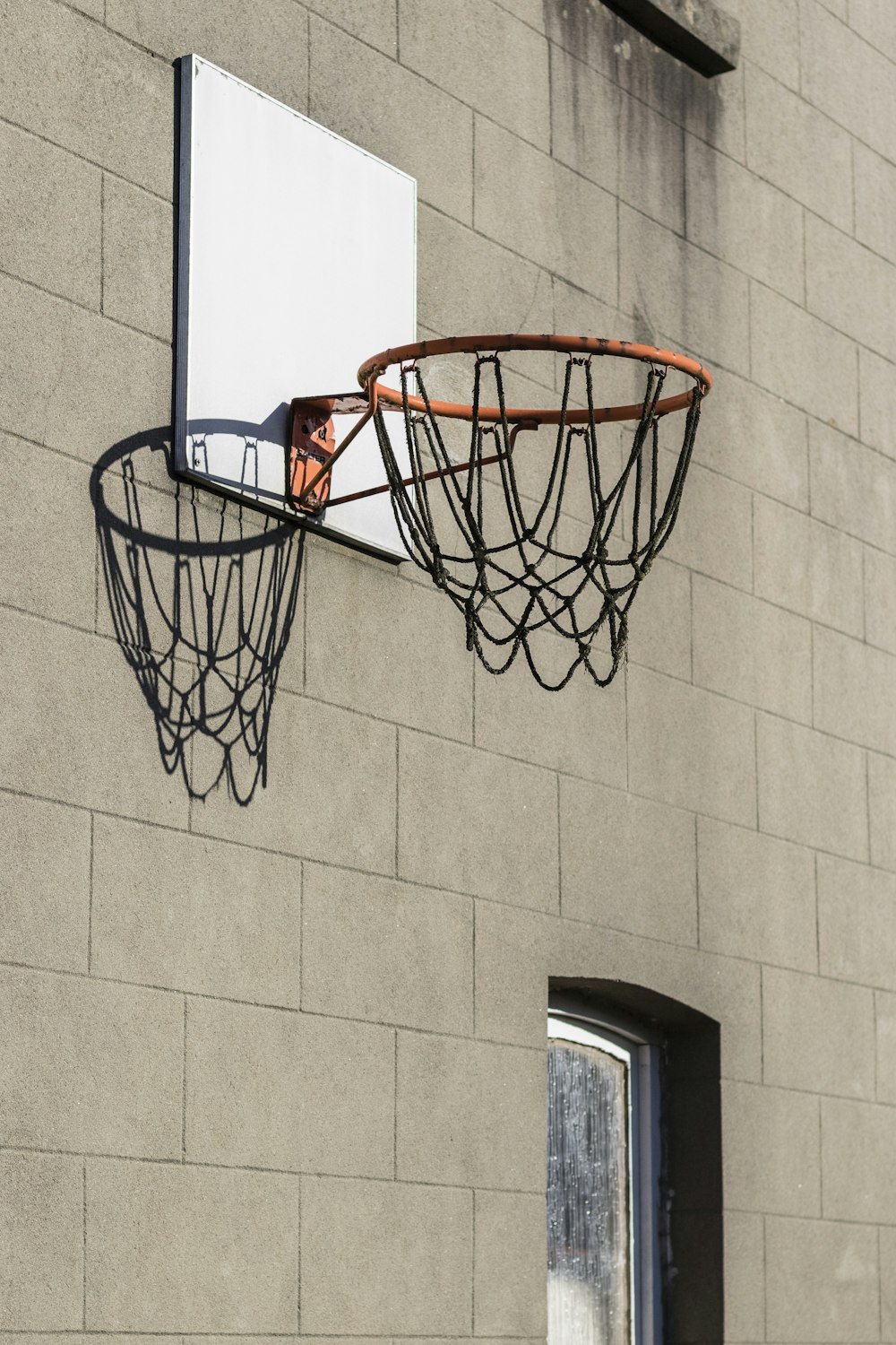 a basketball hoop hanging from the side of a building