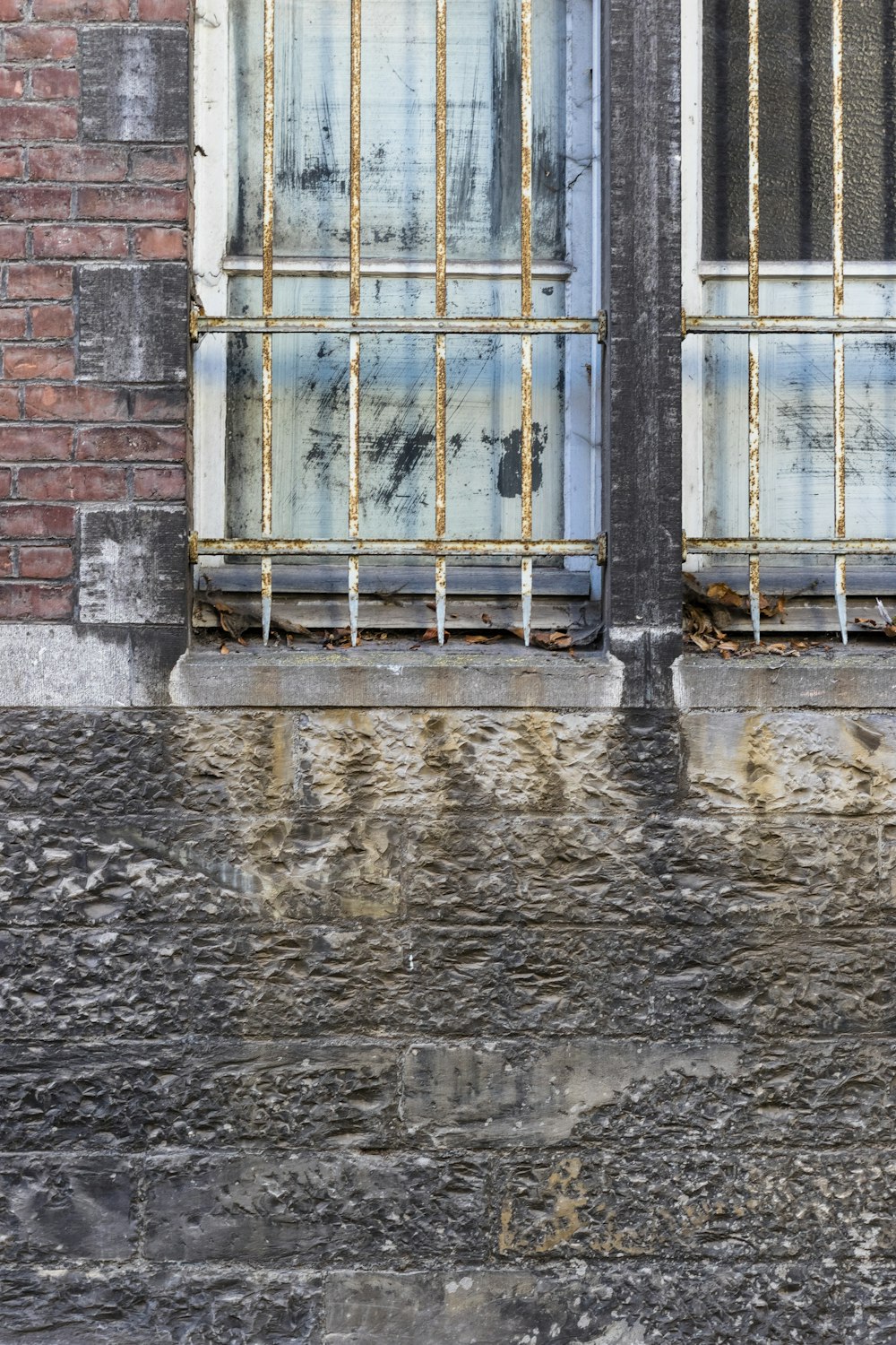 a fire hydrant in front of a window with bars on it