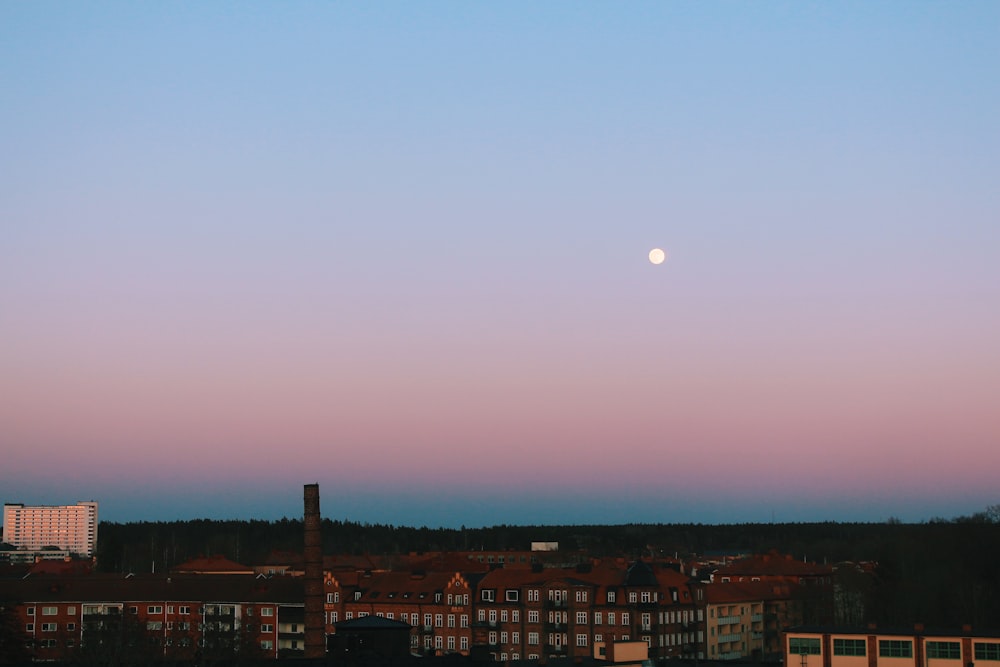 a full moon is seen in the sky over a city