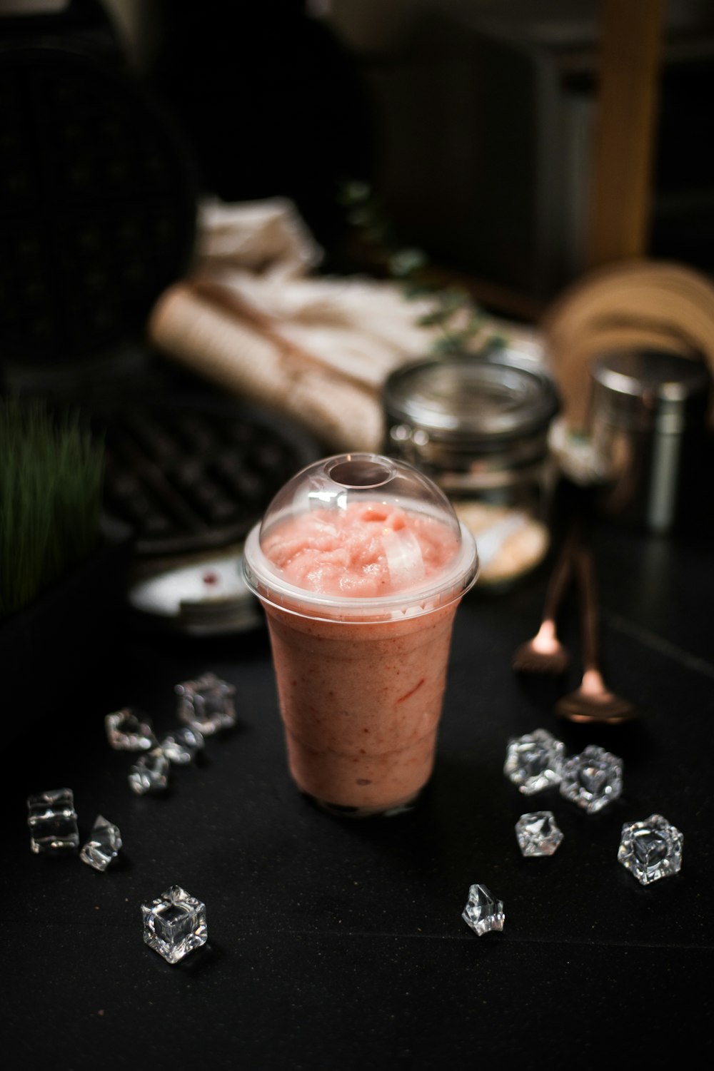 a drink sitting on top of a table next to ice cubes