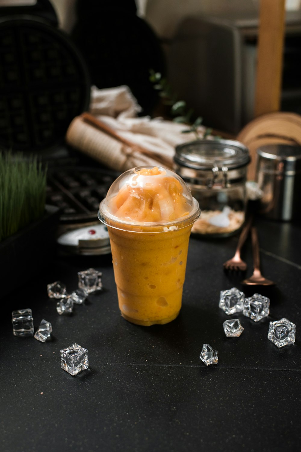 a plastic cup filled with ice on top of a table