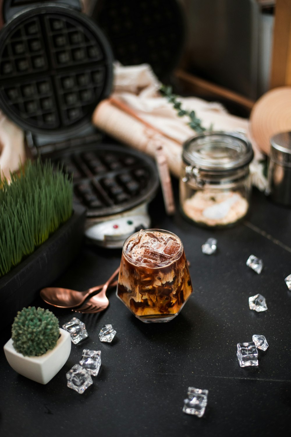 a table topped with waffles and a glass of iced tea