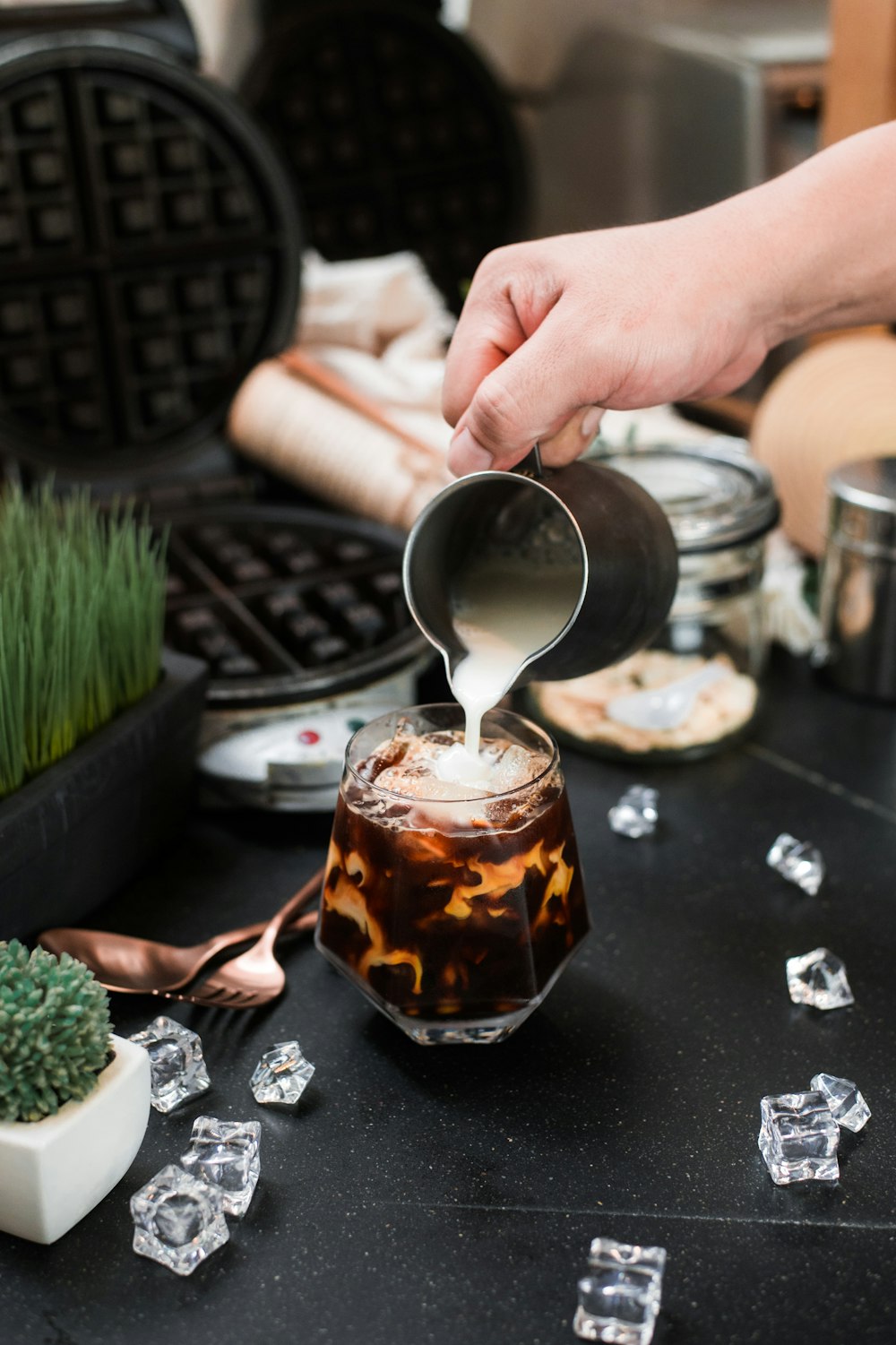 a person pouring a drink into a glass