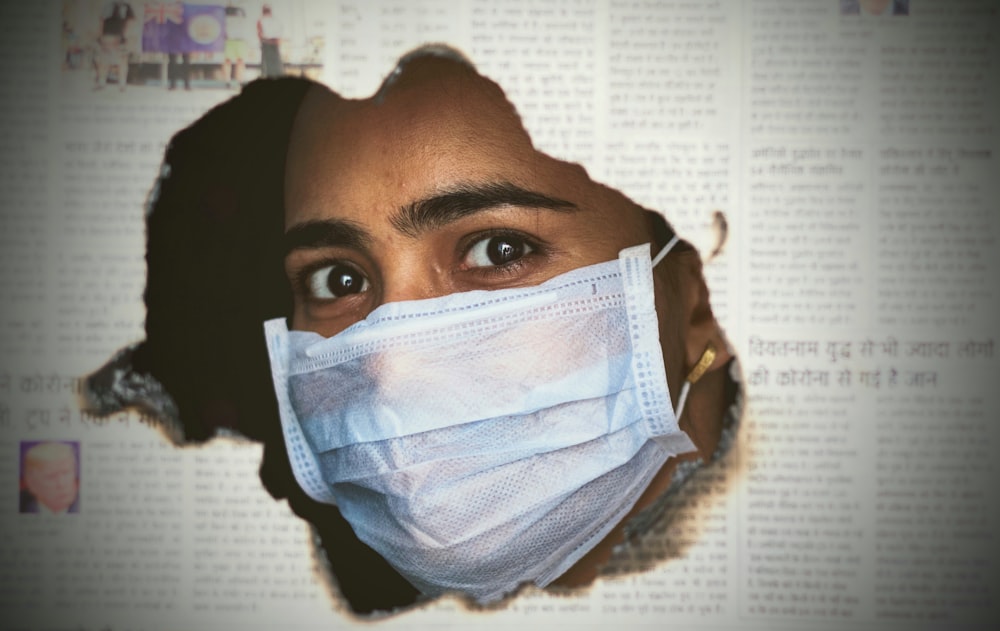 a woman wearing a face mask through a hole