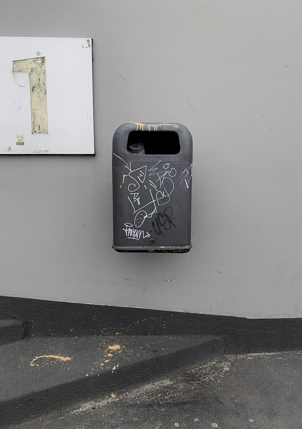 a black mailbox with graffiti on the side of a building
