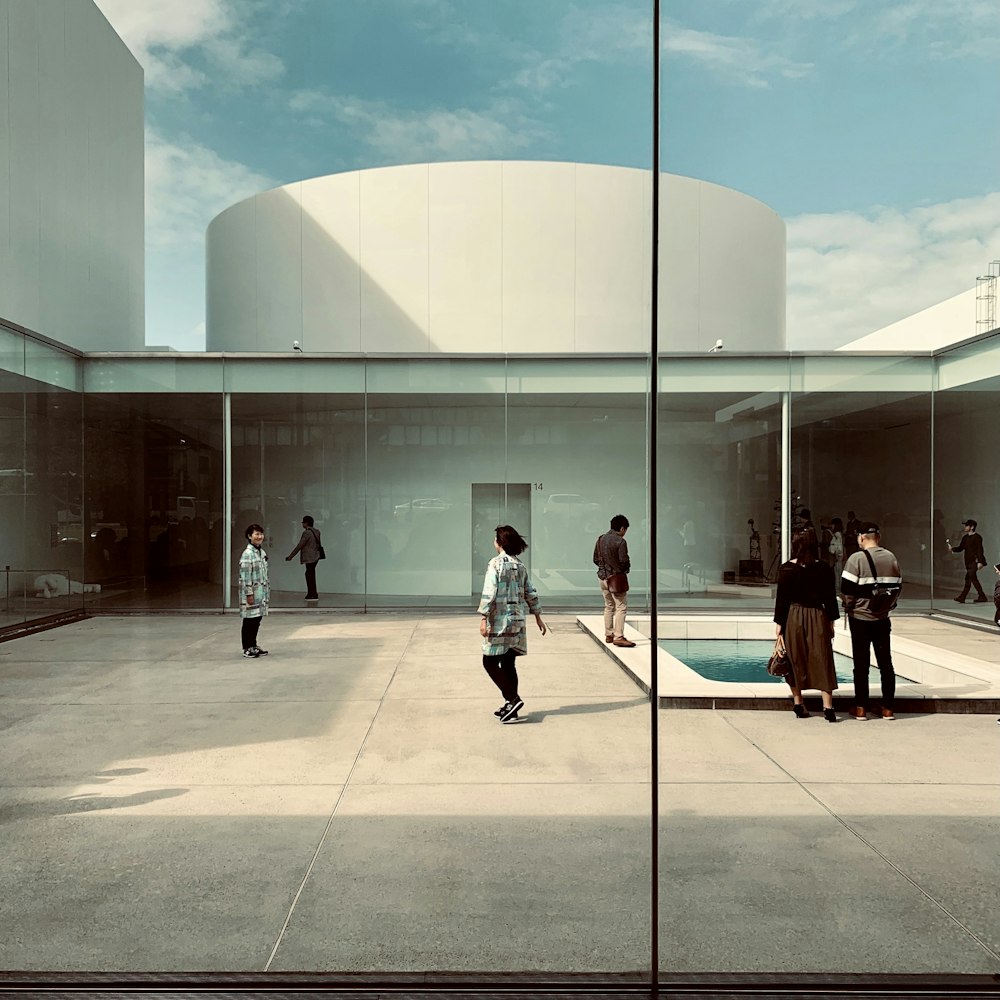 a group of people standing around a pool in a building