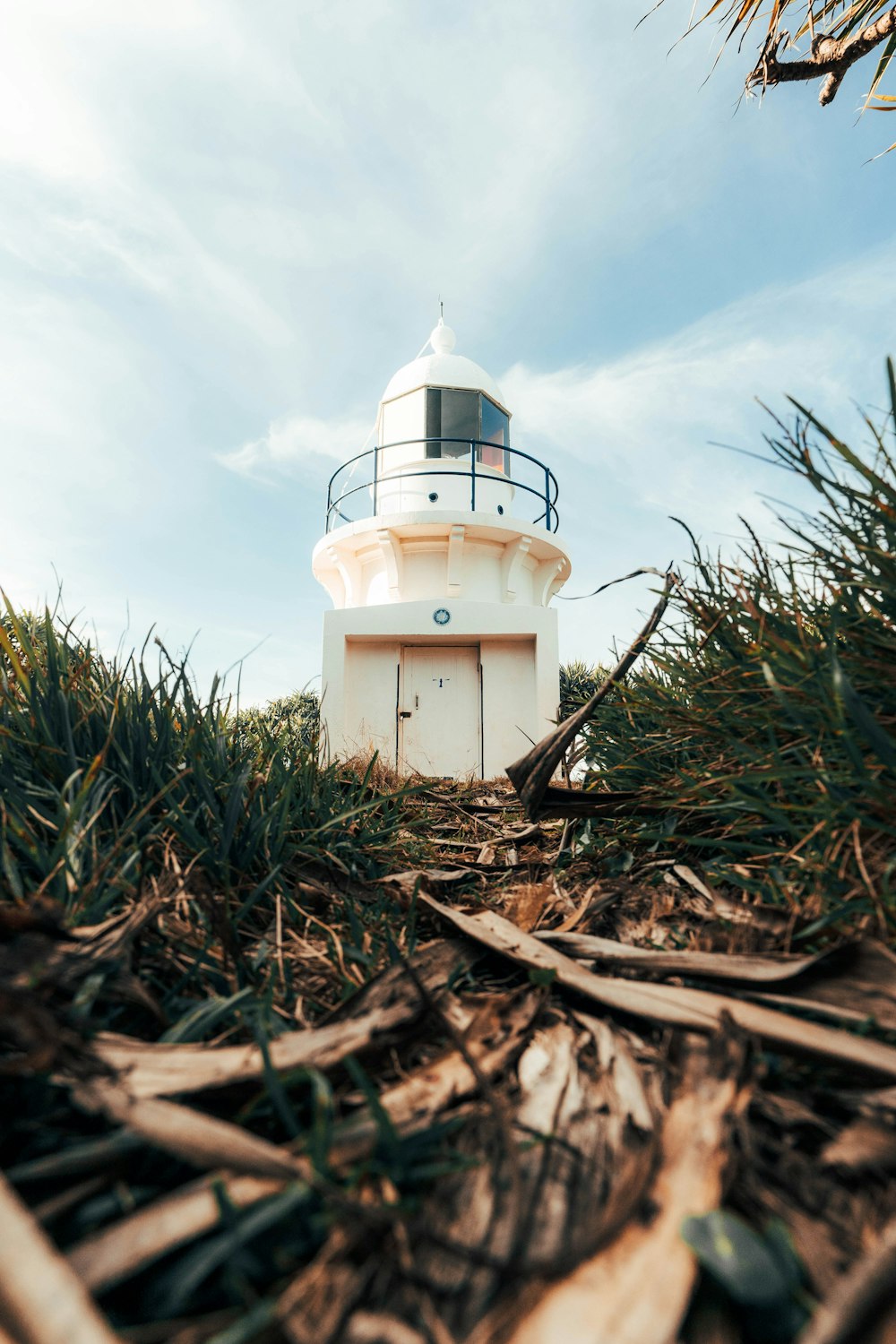 a white lighthouse sitting on top of a lush green field