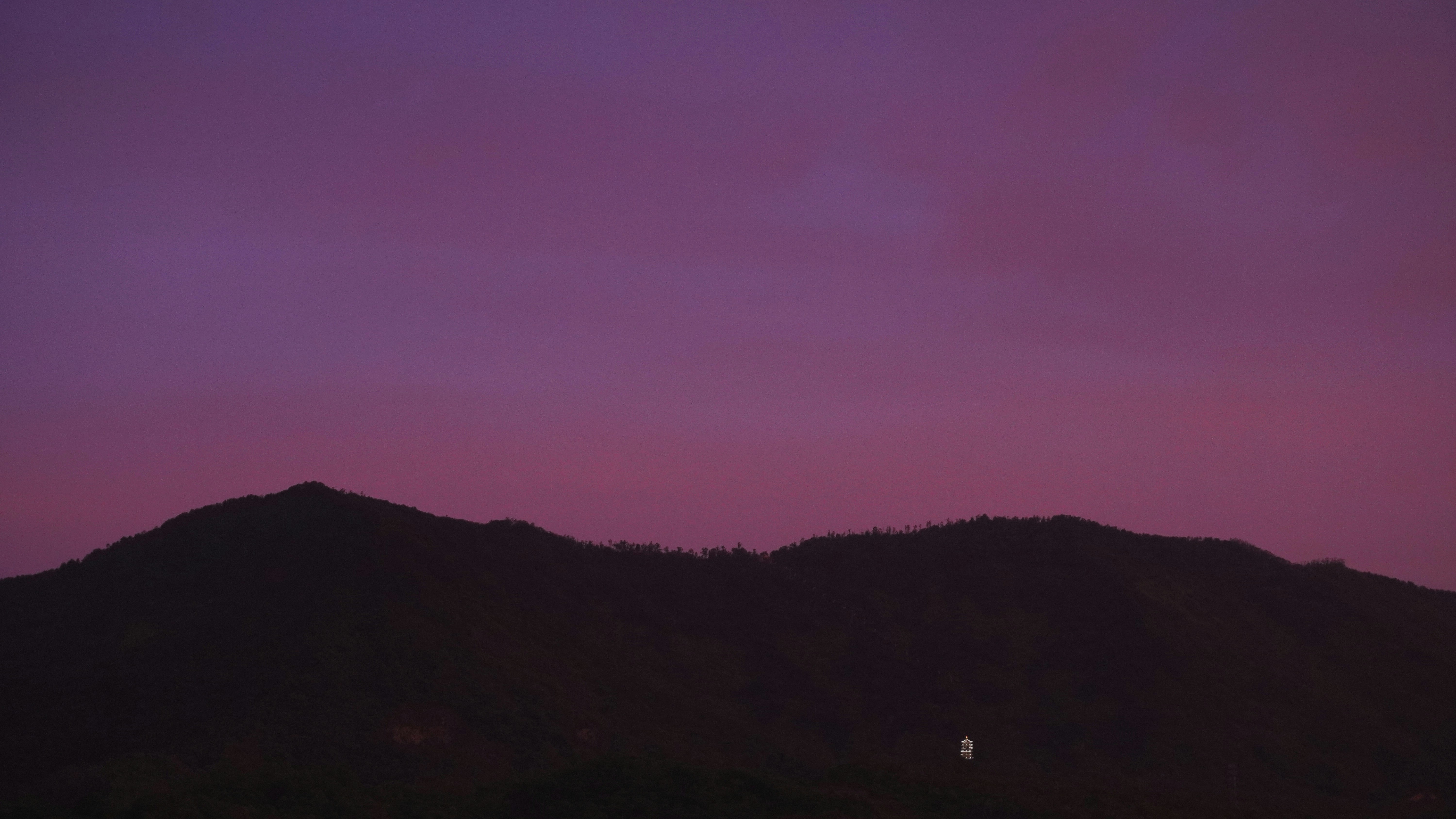 Un cielo viola con una montagna sullo sfondo